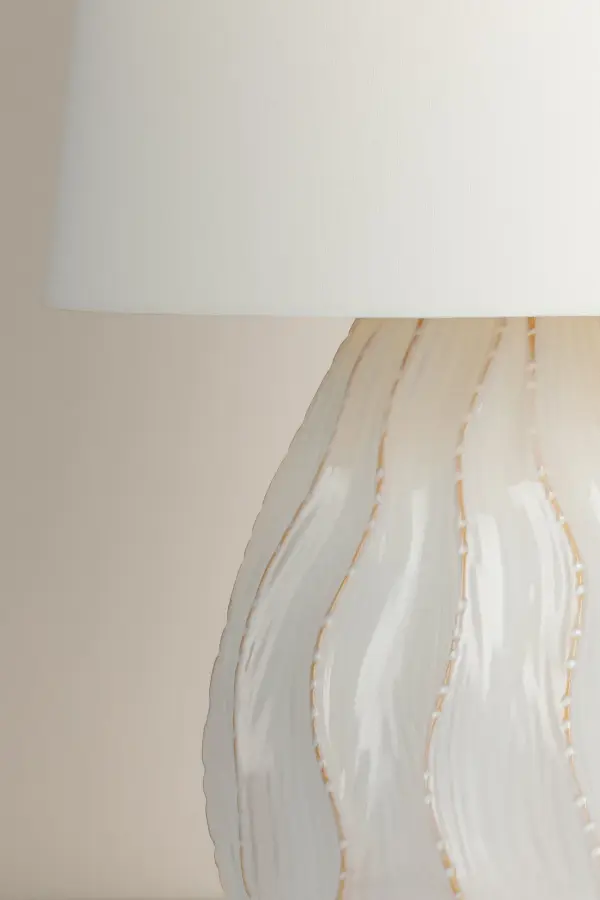 The Karla table lamp brings organic coastal elegance to any space with its whimsical coral-inspired silhouette. Hand-crafted ceramic construction features flowing raised edges and muted pastel tones that showcase natural earthy hues. - alternate view