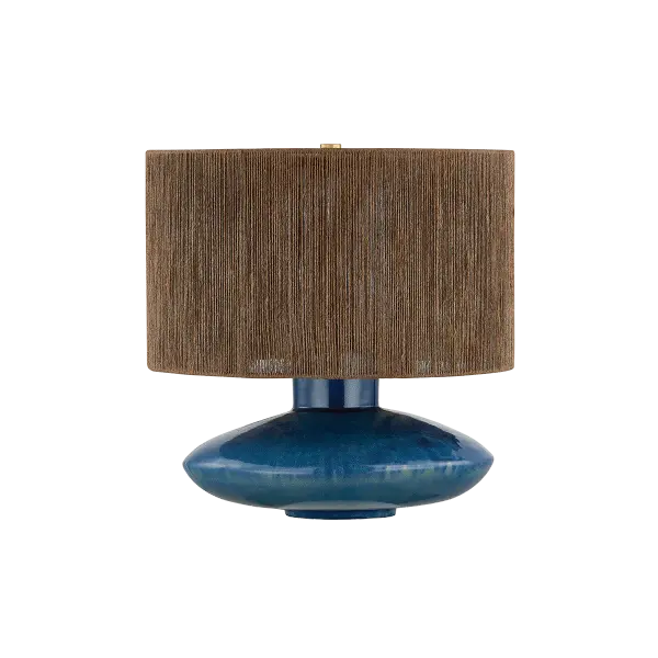 The Enya Table Lamp combines a handcrafted ceramic base with Shadow Amphora glaze and a natural jute shade for organic warmth. Its compact size and bohemian aesthetic make it perfect for bedside or desk use in coastal-inspired spaces.