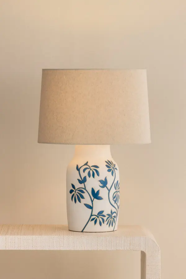 The Yazmeen brings artisanal charm with its hand-glazed ceramic base featuring the distinctive Whitney Floral motif. Each piece is unique, offering one-of-a-kind character paired with a warm sandstone linen shade for organic sophistication. - alternate view