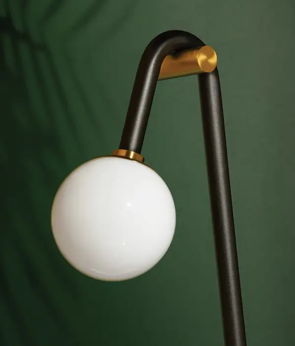The Whit Floor Lamp brings whimsical sophistication to modern interiors with its sweeping black metal tube draped over aged brass accents. Uneven light heights create visual interest and dynamic illumination. - alternate view
