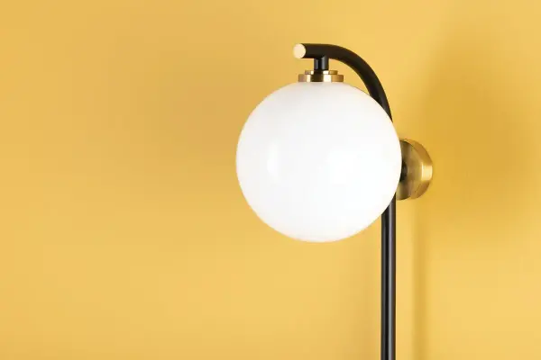 The Faye Plug-In Sconce combines a 3.5-foot tall profile with aged brass accents and an opal glass globe for subtle drama. Its plug-in design offers installation flexibility without hardwiring, perfect for renters or quick room updates. - alternate view