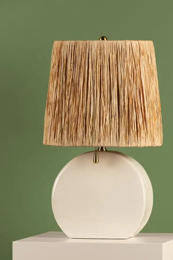The Aneesa Table Lamp combines glossy crackle glaze ceramic with a sophisticated raffia-lined shade and delicate aged brass accents. This transitional piece brings coastal-inspired texture and minimalist jewelry-like details to any space. - alternate view