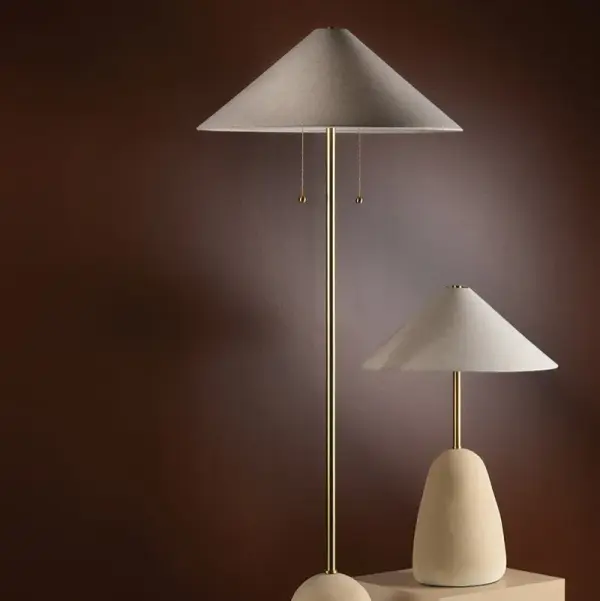 The Maia Floor Lamp is a stunning fusion of cultural influences, featuring a mountain-inspired ceramic base and angular Korean roof-style shade. Aged brass accents add warmth to this neutral, artisanal piece. - alternate view