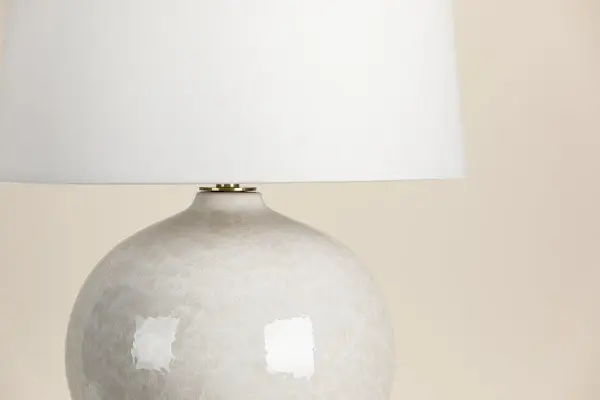 The Karina Table Lamp combines classic design with modern versatility. Its reactive glaze ceramic base and crisp white linen shade create a sophisticated look that complements any décor style. - alternate view