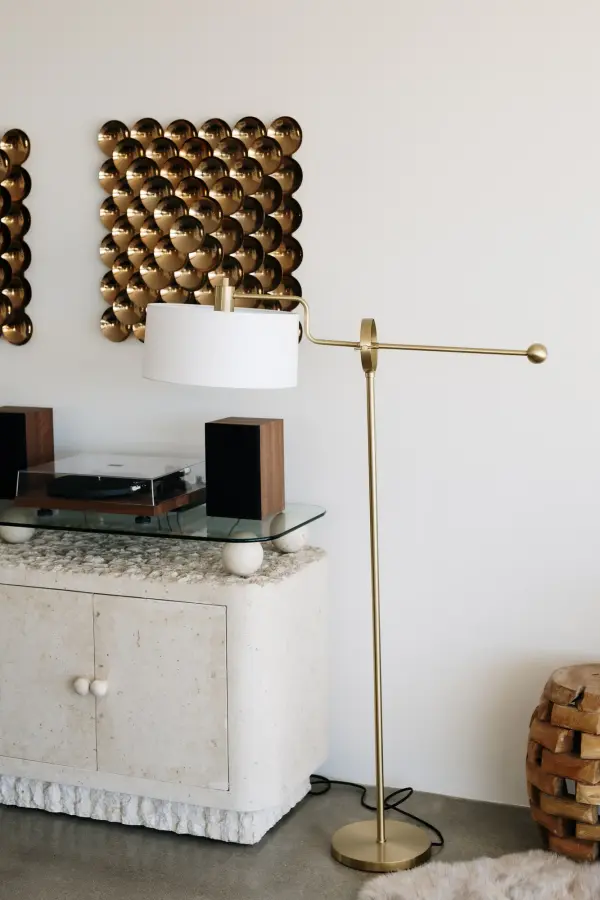 The Libby Floor Lamp combines form and function with its innovative height-adjustable hinge mechanism. The aged brass finish adds warmth and sophistication, while the crisp white drum shade provides focused task lighting. - alternate view