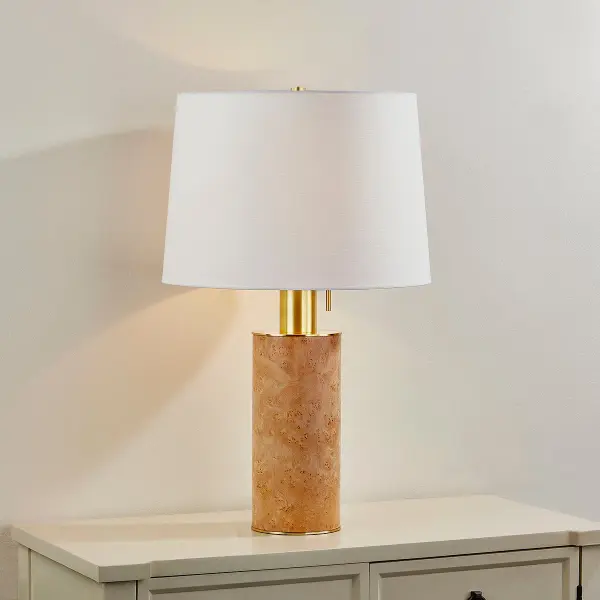 The Clarissa Table Lamp showcases natural burl wood veneer in a modern silhouette, complemented by oversized aged brass hardware and a classic white linen shade. Each piece is unique due to natural wood variations. - alternate view