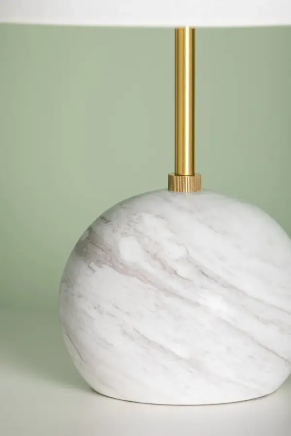The Jewel Table Lamp combines honed Calcutta gold marble with aged brass in a sophisticated geometric design. Its petite stature and luxurious materials make it perfect for adding refined style to intimate spaces. - alternate view