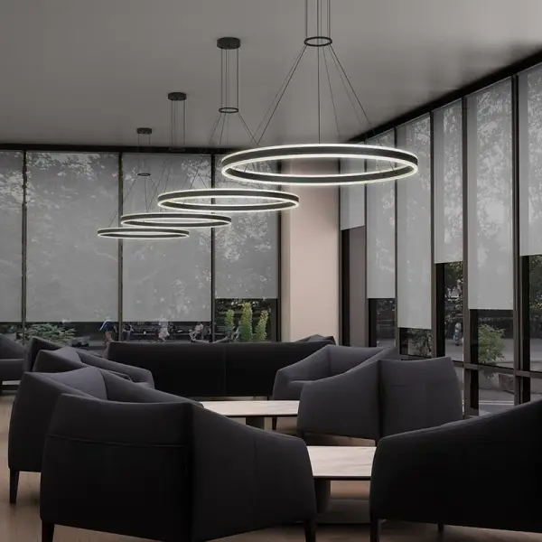 The Double Corona Ring Pendant delivers sophisticated geometric design with LED illumination radiating both upward and downward. Its frosted acrylic rings and sleek aluminum finish create visual impact while providing functional ambient lighting.