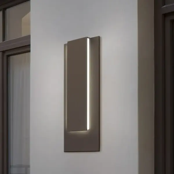 The Reveal Tall LED Sconce combines contemporary design with energy-efficient LED technology. Its textured bronze finish adds warmth and sophistication to any space, while the tall profile creates dramatic vertical interest.