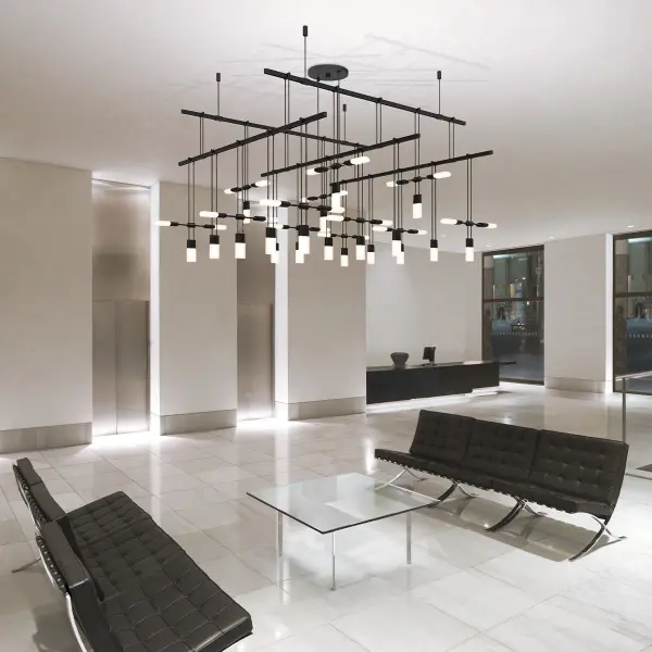 The Suspenders creates a striking cube-like volume through its skeletal structural frame and two-tier design. Etched glass Chiclet luminaires alternate throughout the grid, delivering both architectural drama and functional illumination.