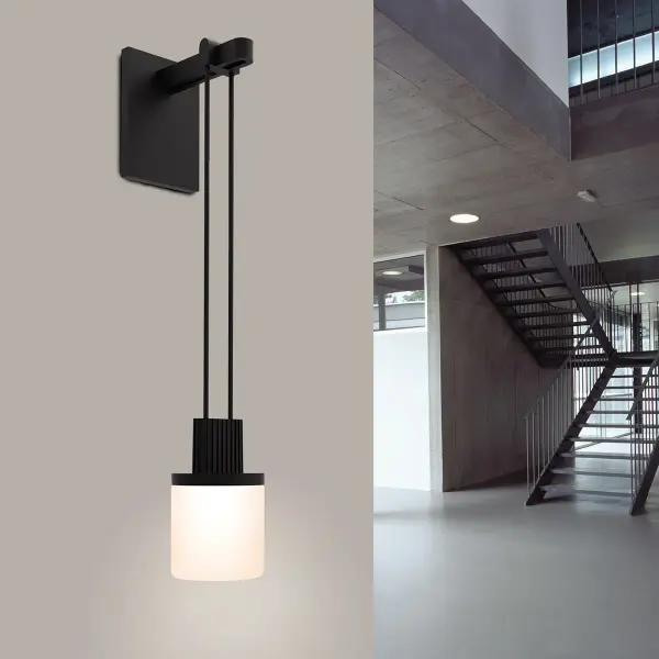 The Suspenders Mini Sconce delivers focused yet gentle lighting through its drum shade design. Perfect for tight spaces, this compact fixture combines contemporary styling with functional illumination in a sleek satin black finish.
