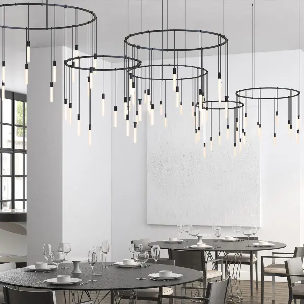 A sophisticated three-ring offset chandelier system featuring etched glass rod luminaires. The modular design allows for limitless positioning combinations, making it ideal for large dining spaces and commercial applications.