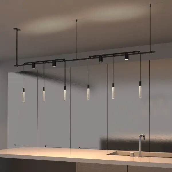 The Suspenders system combines decorative crystal rod luminaires with functional light bars and adjustable cylinders, delivering both ambient glow and focused task lighting in a sleek 73-inch linear design.