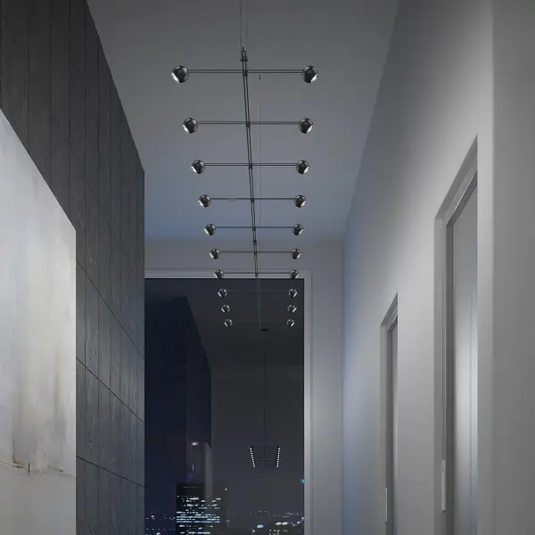 This 96-inch linear chandelier features symmetrically cantilevered aimable sphere luminaires that provide bi-directional illumination. The modular system design offers architectural sophistication with functional flexibility for large-scale spaces.