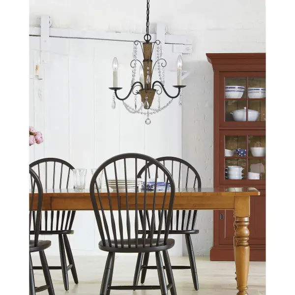 The Antigo chandelier blends organic rattan texture with sparkling crystal elements for a fresh take on traditional elegance. Its compact 19-inch width makes it ideal for smaller dining spaces or bedrooms seeking coastal charm. - alternate view