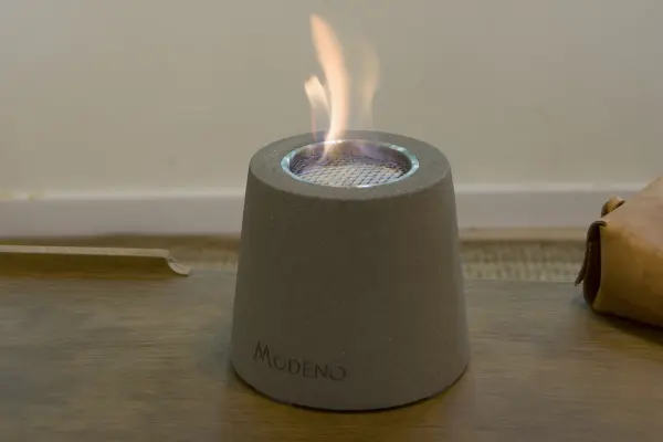 The MODENO ENTTA brings real flame ambiance to any tabletop with its cast concrete construction and clean-burning ethanol fuel. Compact 6.3" footprint fits coffee tables, dining surfaces, or outdoor spaces. - alternate view