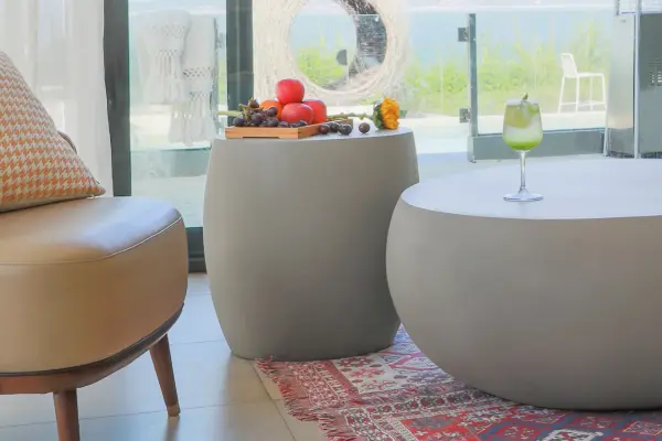 The IKARIA Cobble Side Table combines contemporary design with organic texture. Crafted from glass fiber reinforced concrete (GFRC), this 19-inch square table offers exceptional durability for both indoor and outdoor use. - alternate view