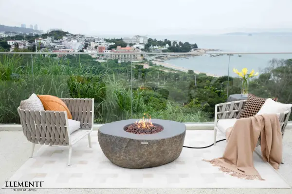 The Elementi Boulder Fire Table combines artisanal concrete craftsmanship with powerful heating performance. Features a 12-inch stainless steel burner ring, push-button ignition, and includes lava rock media and canvas cover. - alternate view