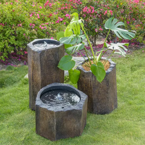 This small basalt fountain showcases rare hexagonal natural stone with authentic surface coloring. At 19" wide and 14" tall, it brings organic modern style to outdoor spaces with its distinctive geometric form and water feature. - alternate view