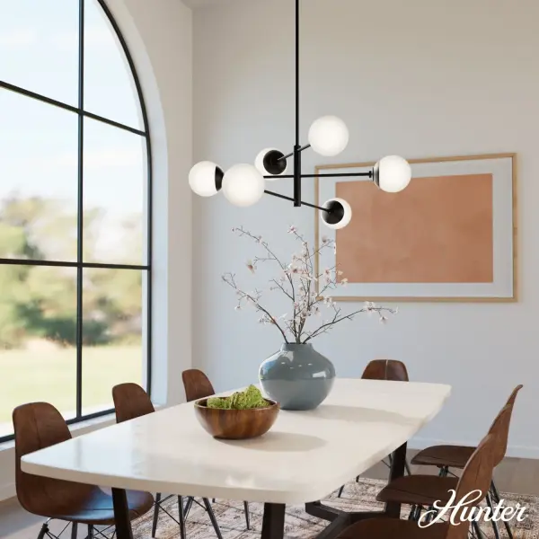 The Hepburn chandelier delivers refined sophistication with its 48-inch linear design and six cased white glass globes. The matte black finish and clean lines create a versatile centerpiece that transitions seamlessly between modern and traditional spaces. - alternate view