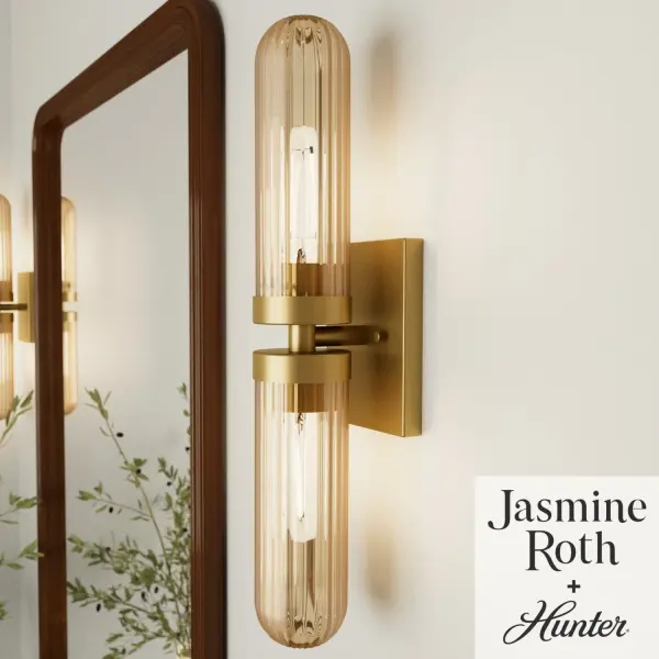 The Beverly Glen vanity light combines formal elegance with modern versatility. Its ribbed amber glass creates a warm, inviting glow while the matte bronze finish adds sophisticated contrast. Damp-rated for bathroom use with flexible mounting options. - alternate view