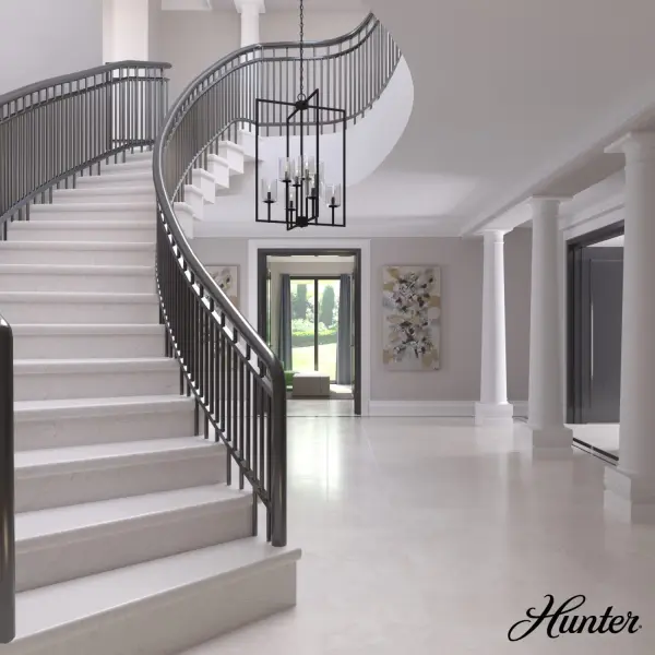 The Kerrison pendant delivers impressive scale and visual impact with its 24-inch square frame and eight candle-style lights. The natural black iron finish paired with seeded glass creates a sophisticated yet approachable aesthetic perfect for grand entryways. - alternate view