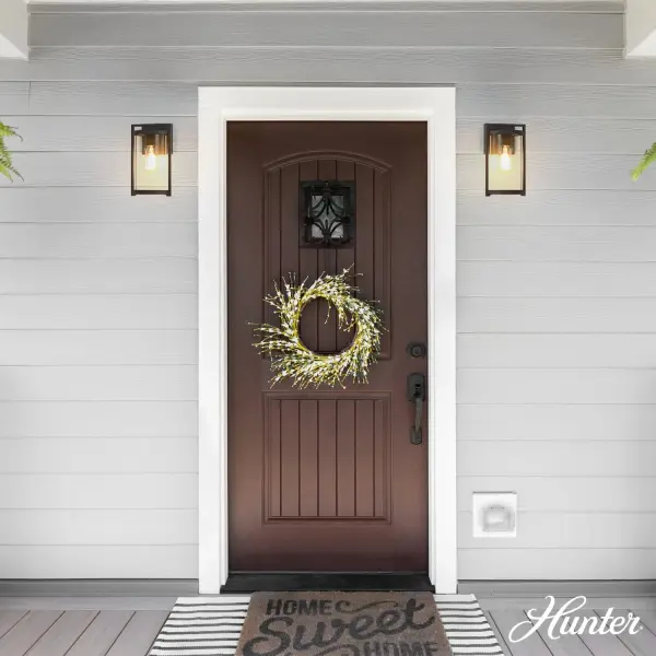 The Astwood outdoor wall light combines modern simplicity with timeless design, featuring a clear cylinder glass shade and durable aluminum construction. Perfect for creating welcoming outdoor spaces with balanced illumination. - alternate view