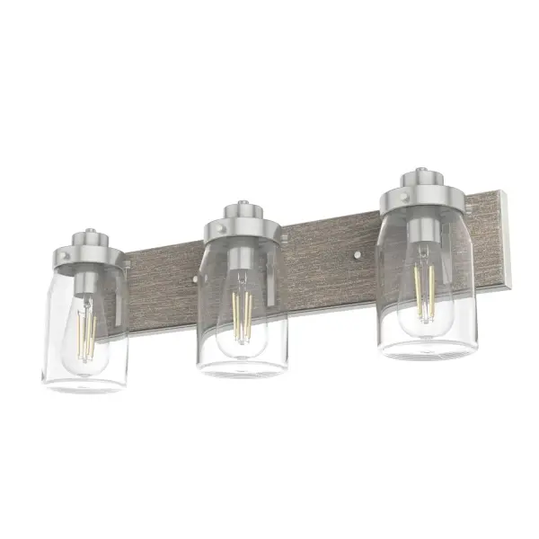The Devon Park combines rustic farmhouse charm with industrial styling in a practical 3-light vanity fixture. Its brushed nickel finish and clear glass shades work beautifully in humid environments, making it ideal for bathrooms and laundry rooms.