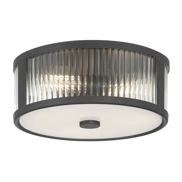 The Ardezia flush mount combines distinctive ribbed glass with a sleek matte black drum frame, creating captivating light patterns. Its versatile mid-century modern aesthetic and warm diffused glow make it ideal for low-ceiling spaces.