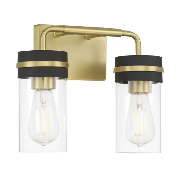 The Marbridge vanity light combines vintage brass and matte black finishes for a sophisticated, design-forward look. Clear glass cylinder shades showcase vintage bulbs beautifully, making it perfect for modern industrial bathrooms.