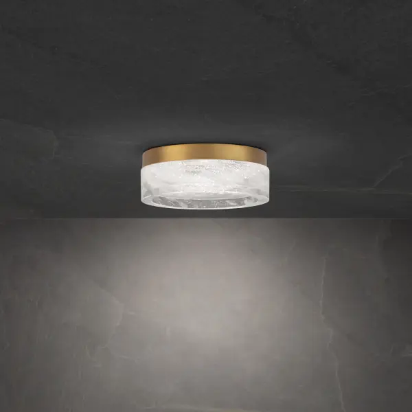 The Melange flush mount combines modern sophistication with artisanal craftsmanship. Its Optic Haze Quartz shade creates a soft, diffused glow while the aged brass finish adds warmth. Perfect for low-ceiling spaces requiring ambient lighting.