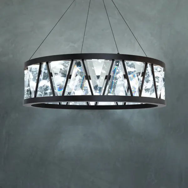 Adorned with with large trillion-diamond shaped Schonbek Optic Haze® Quartz that mimic natural quartz gemstones. Corinth is a new statement on crystal. Hidden light sources and powered aircraft cables elevate a conservative profile with intrigue and technology. The solid double ring body is finished in quartz Haze® and deploys ambient up lighting.
