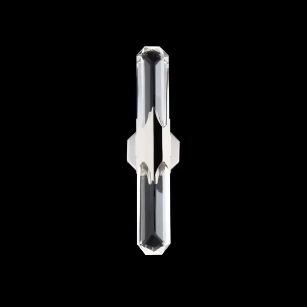 The glamour and precision of Art Deco design is expressed through the striking vertical form of the Sabine wall sconce. A faceted Optic Crystal  rod serves as the luminous centerpiece, with elongated planes and prismatic edges echoing the streamlined geometry and luxe materials that defined the era. At the center, a stylized triangular motif embraces the crystal with sculptural symmetry.