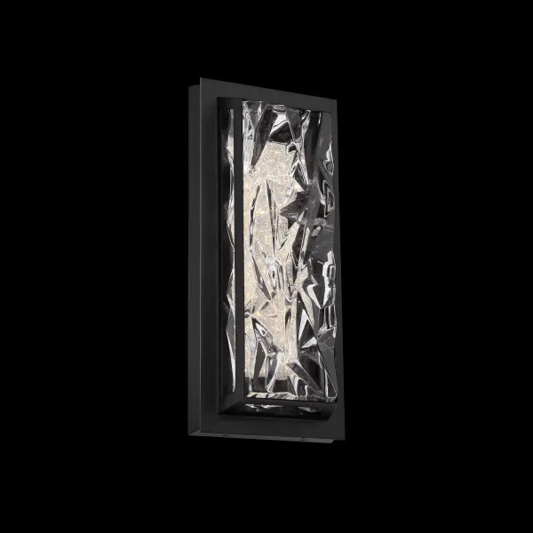 Drizzle channels the crystalline drama of sculpted ice into a sleek architectural form. Its pressed-glass diffuser features sharp, multifaceted textures that refract illumination with the depth and brilliance of frozen water catching the light. A clean metal frame outlines the glass with modern precision, adding structure, contrast, and visual rhythm.