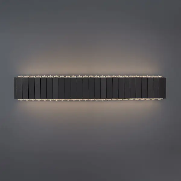 Bars of natural wood, alive with raw grain and texture, create a warm yet striking frame. Inside, faceted Radiance® Crystal elements flash like cut gems, bouncing light in a hypnotic rhythm. Soft illumination pours up and down through the crystals, flooding the room with a moody, captivating glow. It’s more than a wall sconce—it’s an artful collision of nature and luxury, designed to turn heads.