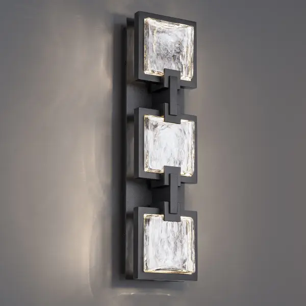 Meet Pop Star—an outdoor wall light that thrives on performing. Three square crystal panels each etched with a striking starburst pattern, are secured by sleek metallic accents against a rectangular aged brass backplate. Concealed LEDs edge-light each incised square, creating an ambient glow that highlights every detail. Finished with a weather-resistant powder coat, this piece is built to command attention, rain or shine.