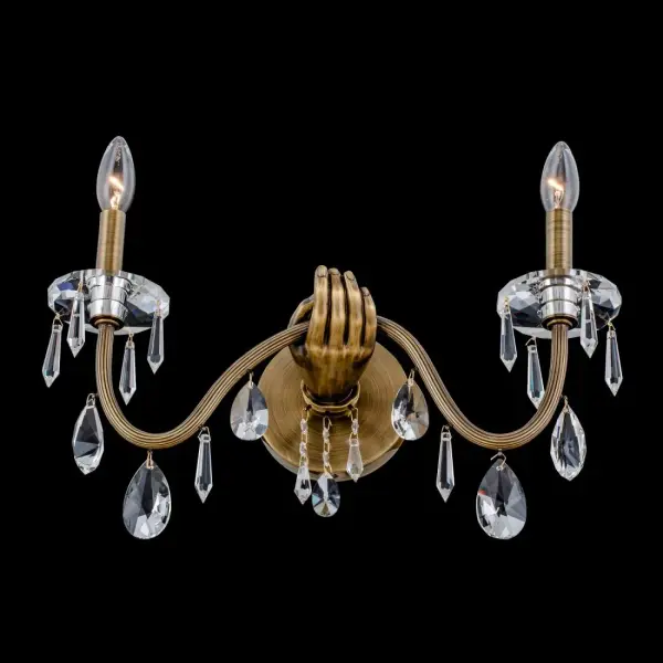 The Venere wall sconce transforms lighting into art with its surrealist-inspired design. Cast solid brass construction features clear Firenze crystal drops and bobeches, creating dramatic visual interest while providing elegant ambient lighting.