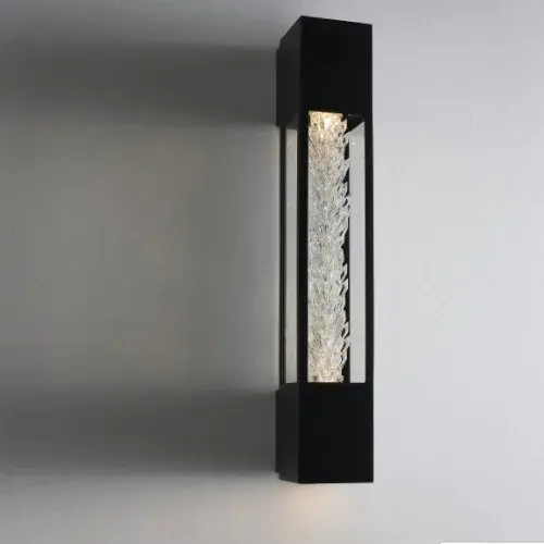 The Drita Outdoor Sconce features clear Firenze crystals clustered in an organic column shape, creating a raw gem aesthetic. WET-rated for outdoor use with integrated LED downlighting, perfect for illuminating entryways and stairs.