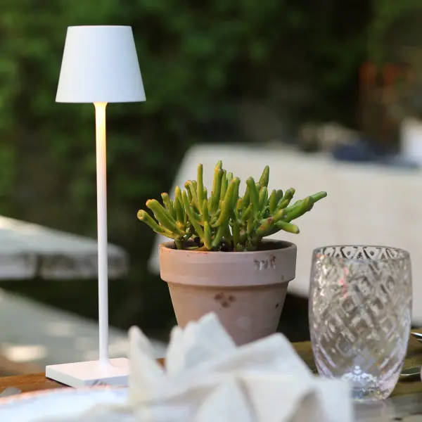 The Poldina Pro Micro is a sophisticated cordless table lamp featuring touch dimming, three color temperature settings, and IP65 outdoor rating. Its compact 10.8-inch height and decorative gold leaf crackle finish make it perfect for intimate spaces both indoors and out. - alternate view