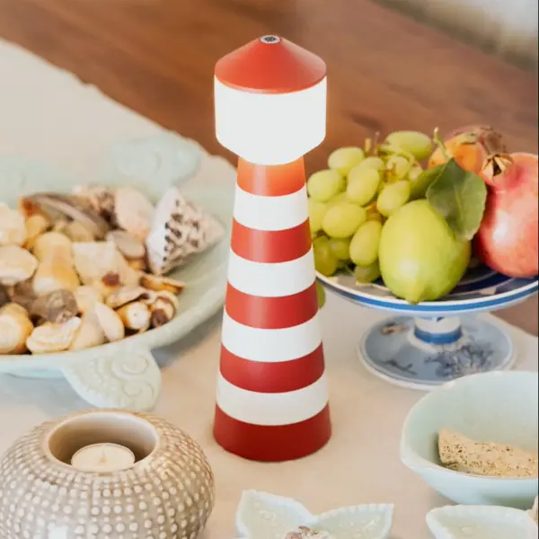 The Ocean Cay brings Italian design and maritime charm to any space with its iconic red and white striped lighthouse aesthetic. This portable, cordless lamp offers exceptional versatility with adjustable brightness, three color temperatures, and up to 11 hours of battery life. - alternate view