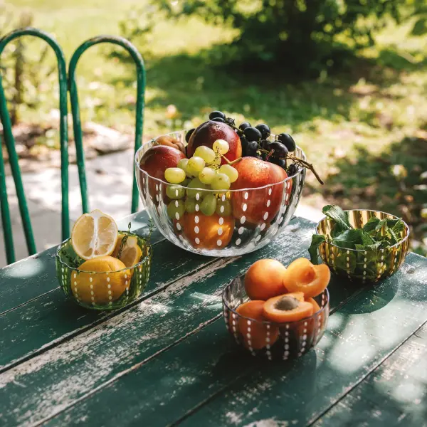 The Perle Large Bowl is a stunning artisanal piece featuring transparent colored glass and glass paste construction. Its handcrafted nature creates enchanting light reflections, adding vibrant elegance to any table setting. - alternate view