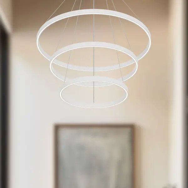 The Cerchio 32-inch chandelier makes a bold architectural statement with its three-tier circular design and integrated LED lighting. Crafted from extruded aluminum with a matte black finish and silicone diffusers, it delivers warm ambient light perfect for contemporary dining rooms and living spaces. - alternate view