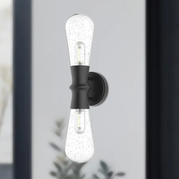The Marcel wall sconce combines swooping clear bubble glass with a textured black metal frame for a contemporary aesthetic. Its compact 5-inch design and weather-resistant construction make it ideal for both interior and exterior applications. - alternate view