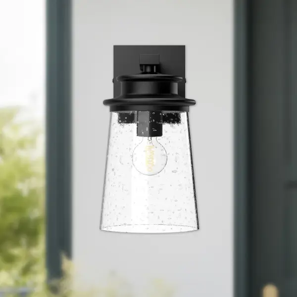 The Quincy wall sconce brings architectural elegance with its layered pagoda-inspired design in textured black finish. Clear bubble glass adds vintage charm while the versatile mounting works beautifully indoors or out. - alternate view