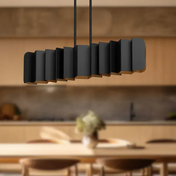 The Akira 42-inch linear pendant makes a bold artistic statement with its folded black metal exterior and brushed gold interior. Perfect for modern spaces seeking texture and visual interest over dining tables or kitchen islands. - alternate view