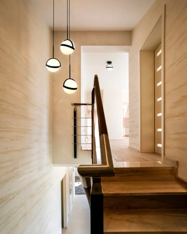 The Globo 3-Light Multi Pendant combines modern design with functional versatility. White orbs wrapped in brushed gold bands can be tilted to direct light, creating a customizable lighting experience perfect for dining and living spaces. - alternate view