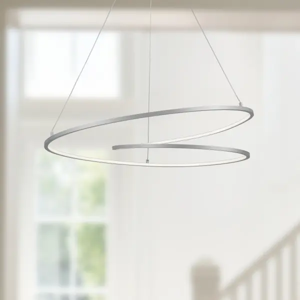 The Twist pendant features a distinctive extruded aluminum loop design with flexible silicon diffuser providing both up and down light. Its 32-inch length makes it perfect for kitchen islands and dining tables, while the warm antique brass finish adds contemporary elegance. - alternate view