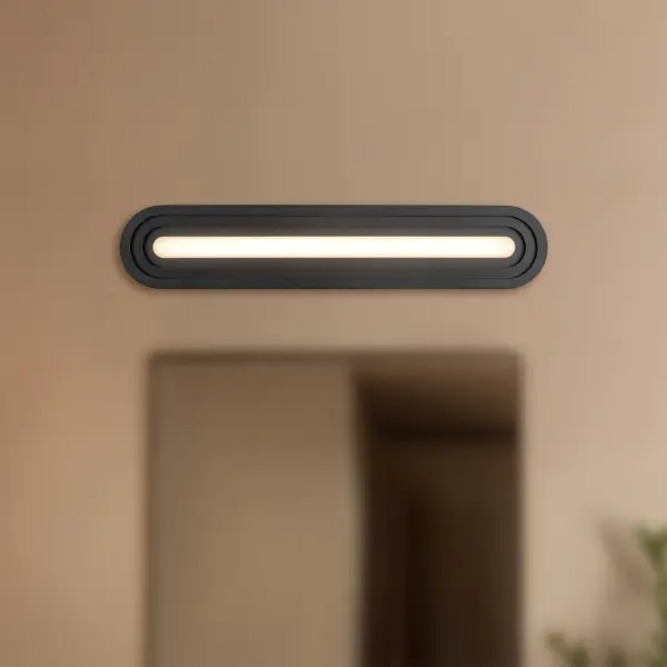 The Arco vanity light brings contemporary elegance to bathroom spaces with its distinctive pill-shaped silhouette and layered frame design. Integrated 3000K LED provides warm, energy-efficient illumination perfect for grooming tasks. - alternate view