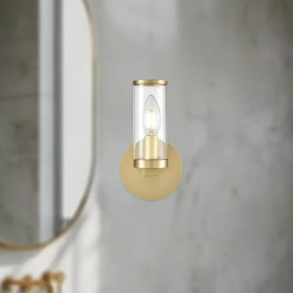 The Revolve vanity light brings timeless elegance to bathrooms and powder rooms with clear glass tubes and metal ring accents reminiscent of antique candle-holders. Its Natural Brass finish adds warmth and sophistication. - alternate view