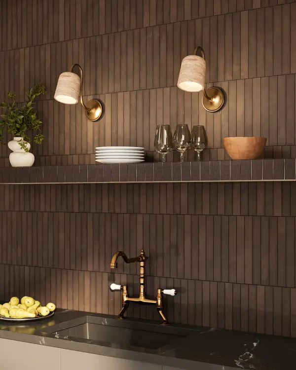 The Bromley wall sconce combines organic elegance with modern sophistication through its natural travertine stone shade and gracefully curved matte black arm. This refined gooseneck design adds sculptural interest and warm, textured lighting to bathrooms, hallways, and kitchens. - alternate view